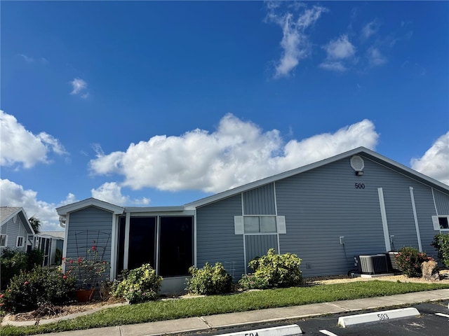 rear view of house featuring a sunroom and central air condition unit