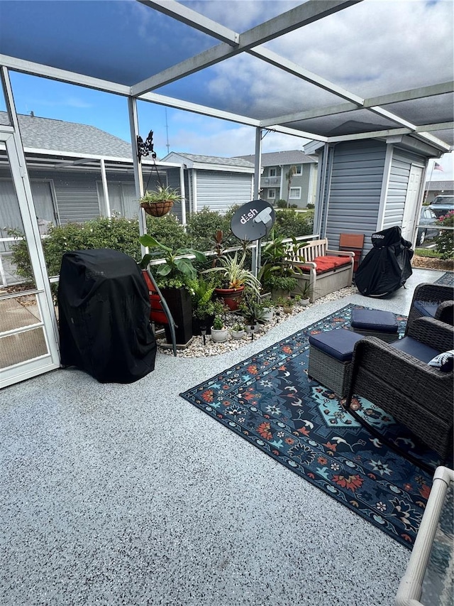 view of patio with area for grilling and a lanai