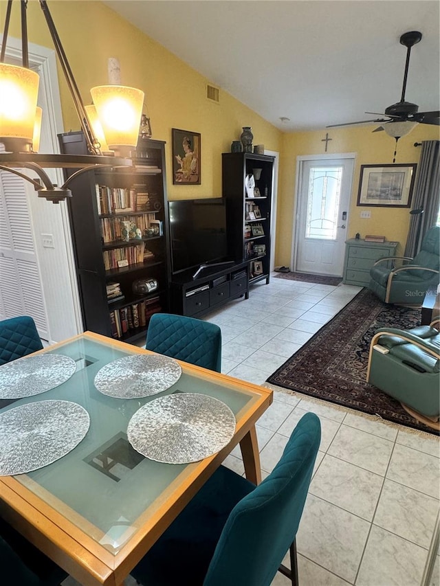 dining space featuring ceiling fan, light tile patterned floors, and lofted ceiling