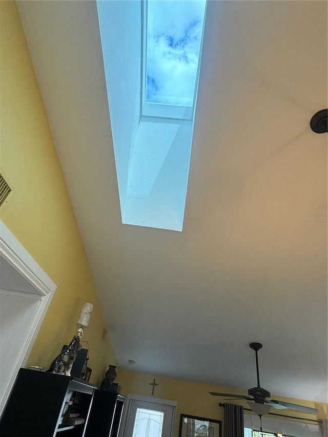 interior details with ceiling fan and a skylight