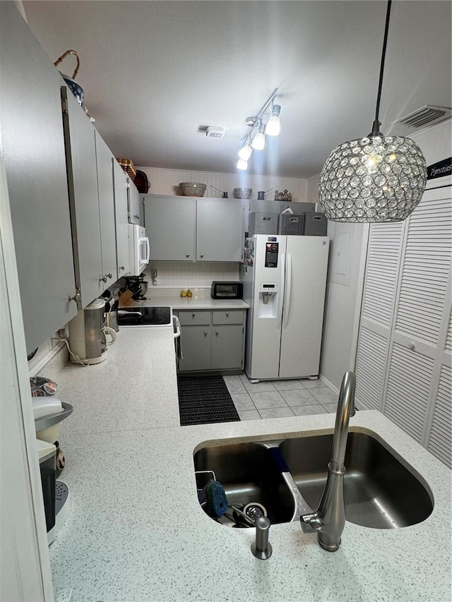 kitchen with gray cabinets, white appliances, sink, and hanging light fixtures