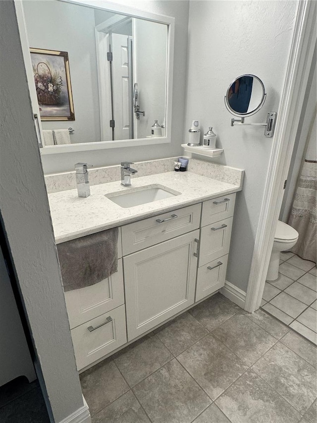 bathroom with tile patterned floors, vanity, and toilet