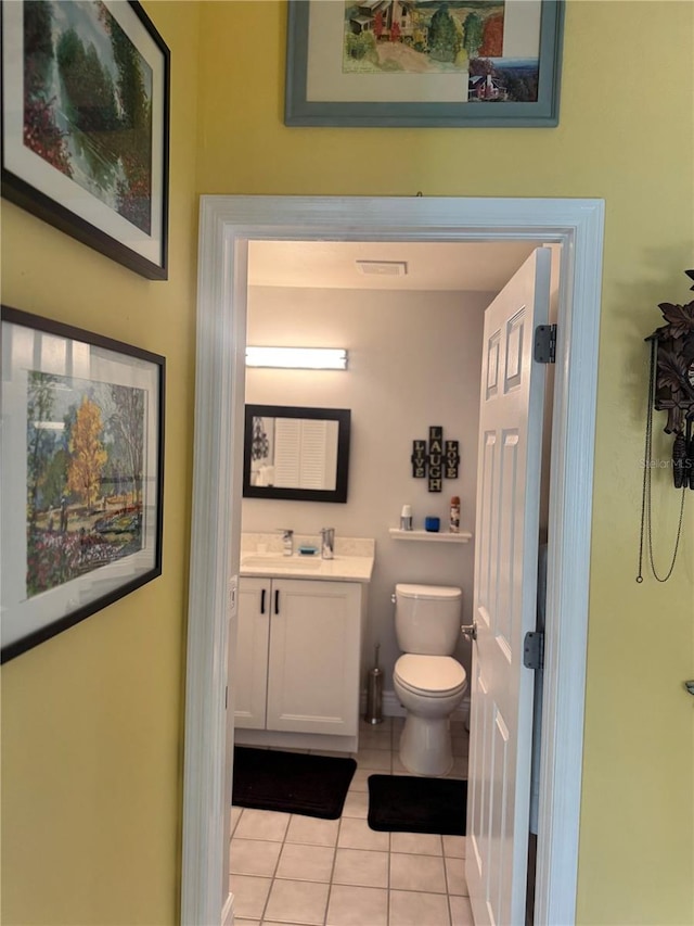 bathroom with tile patterned flooring, vanity, and toilet