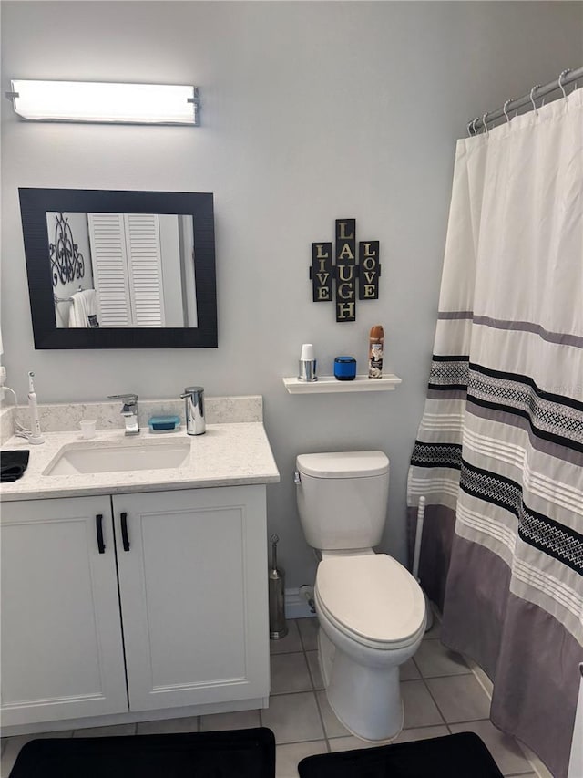 bathroom featuring toilet, a shower with curtain, vanity, and tile patterned floors