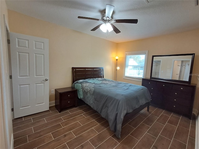 bedroom with ceiling fan and a textured ceiling