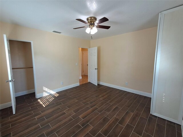 unfurnished room with ceiling fan and dark hardwood / wood-style floors