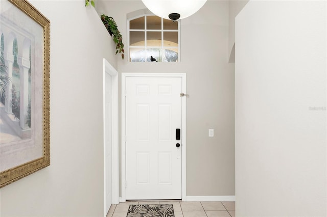 interior space with light tile patterned floors and a high ceiling