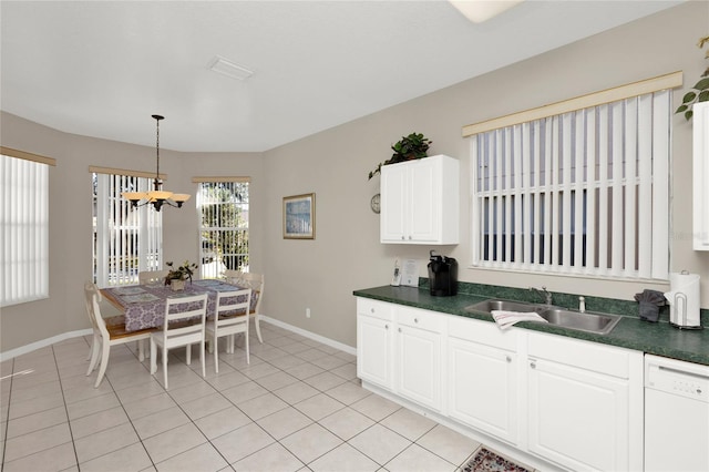 kitchen with pendant lighting, white dishwasher, sink, light tile patterned flooring, and white cabinetry