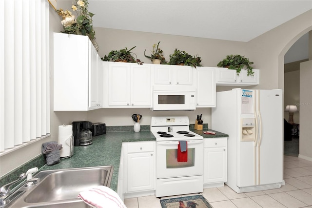 kitchen featuring white cabinets, light tile patterned floors, white appliances, and sink