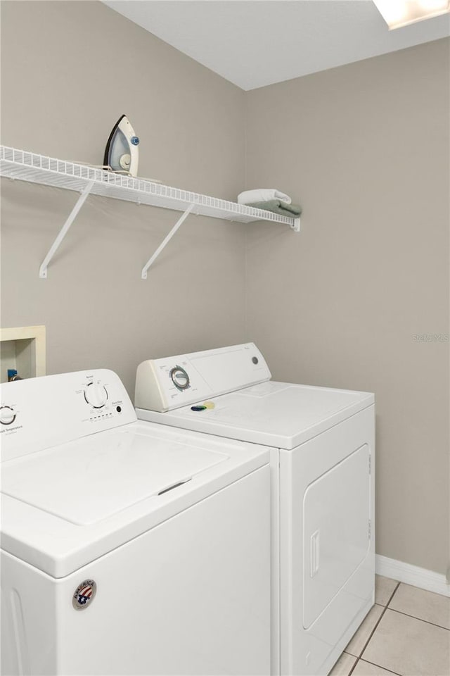 clothes washing area with separate washer and dryer and light tile patterned floors