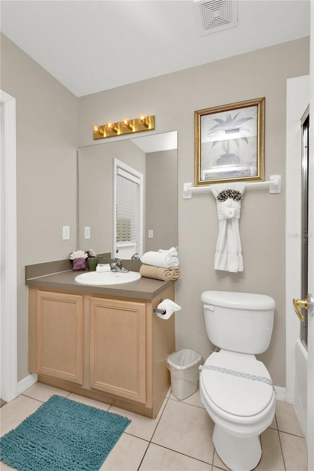 full bathroom with tile patterned floors, vanity, bath / shower combo with glass door, and toilet