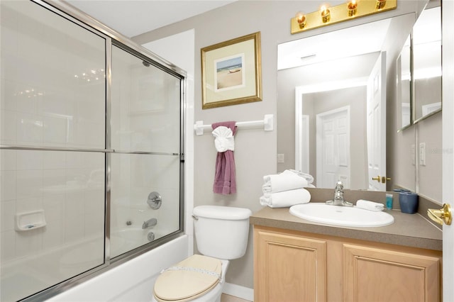 full bathroom with combined bath / shower with glass door, toilet, and vanity