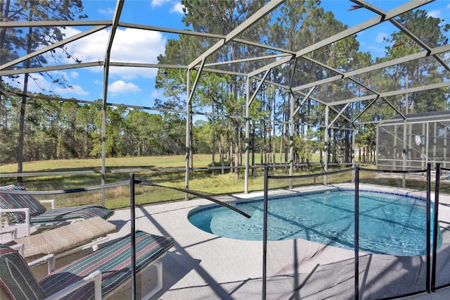 view of pool featuring a patio area, a lanai, and a lawn