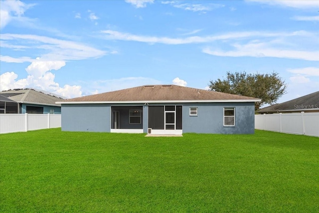 back of house featuring a yard and a sunroom