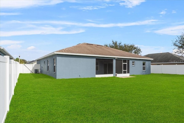 back of house featuring a sunroom and a yard