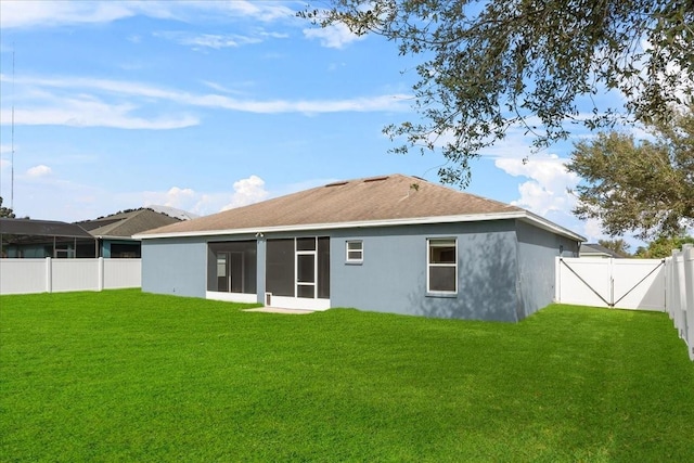 back of house with a yard and a sunroom