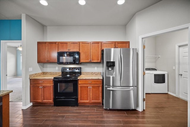 kitchen featuring light stone countertops, black appliances, and independent washer and dryer