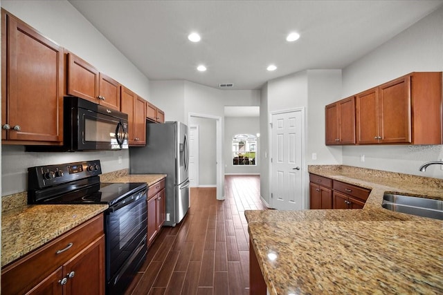 kitchen featuring light stone counters, sink, black appliances, and dark hardwood / wood-style floors