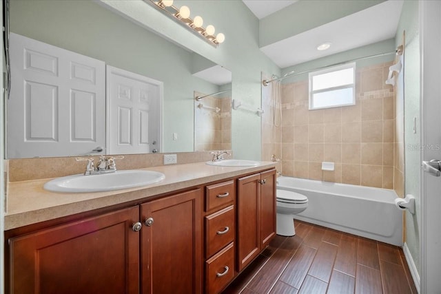 full bathroom with vanity, tiled shower / bath, and toilet