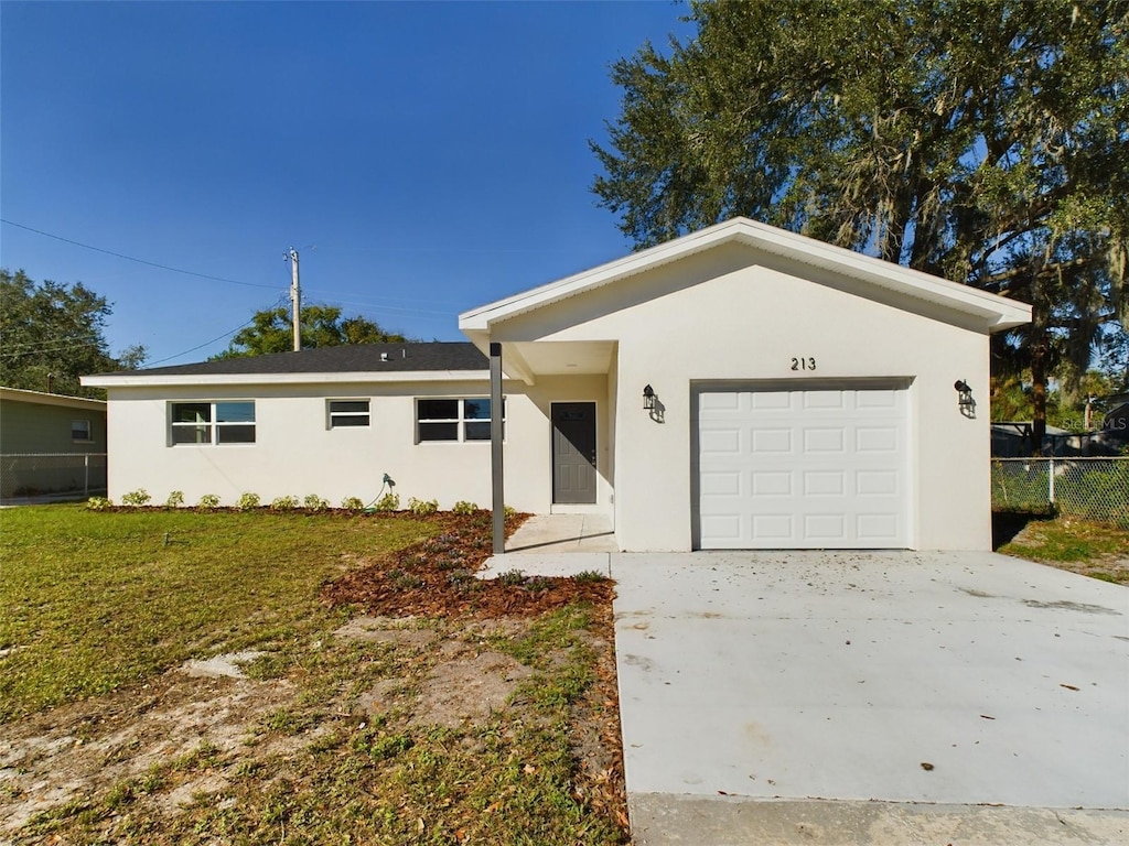 ranch-style home with a garage and a front lawn