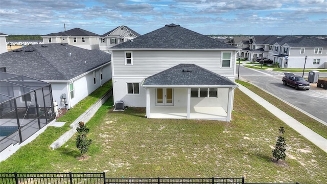 back of property with glass enclosure, a patio area, a yard, and cooling unit