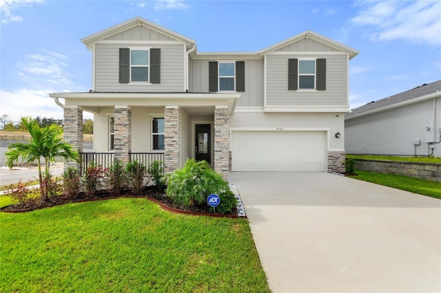 craftsman-style house featuring covered porch, a garage, and a front lawn