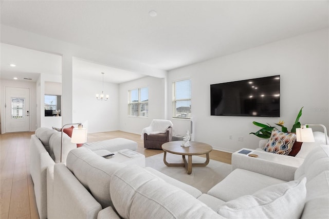 living room featuring light hardwood / wood-style flooring and a notable chandelier