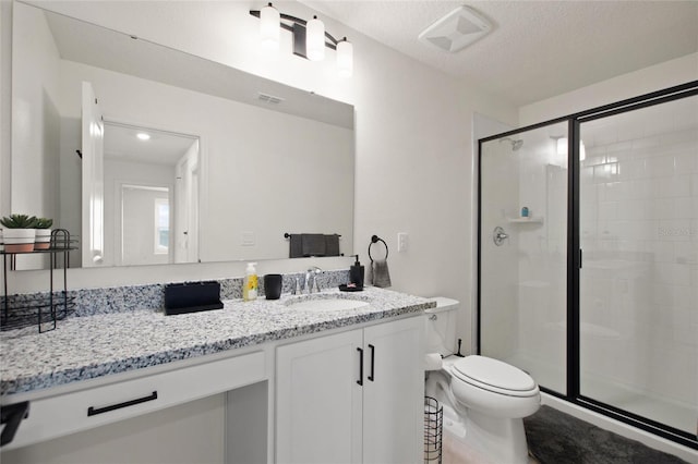 bathroom featuring tile patterned floors, a textured ceiling, toilet, a shower with door, and vanity