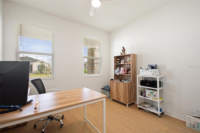 home office with light hardwood / wood-style flooring, plenty of natural light, and ceiling fan