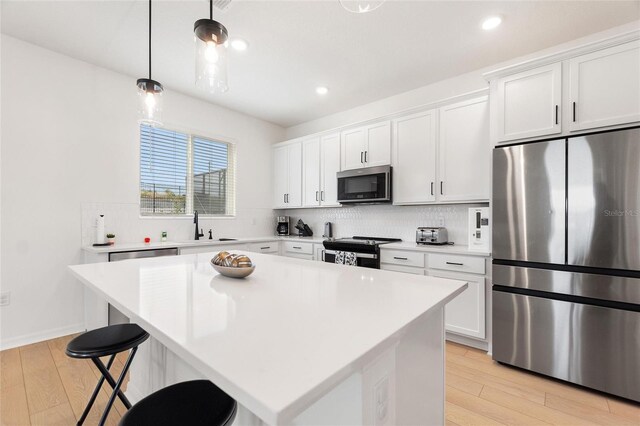 9660 Westside Hills Dr, Davenport, FL 33896 - kitchen with stainless steel appliances, light wood finished floors, backsplash, a kitchen island, and recessed lighting