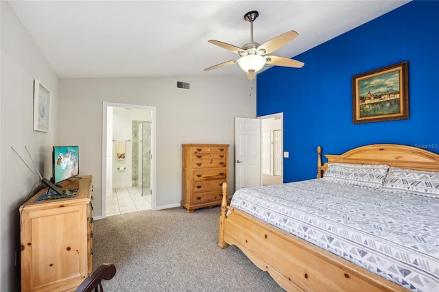 carpeted bedroom with ceiling fan, vaulted ceiling, and ensuite bath