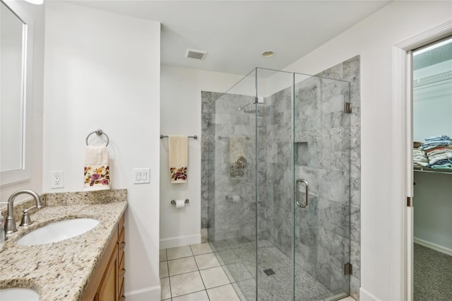 bathroom with tile patterned flooring, vanity, and walk in shower