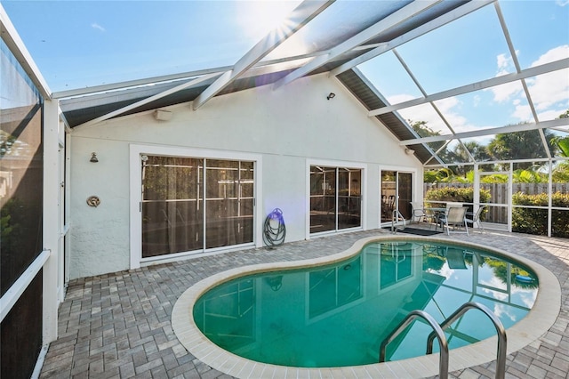 view of swimming pool featuring glass enclosure and a patio area