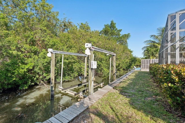 view of dock with glass enclosure and a water view