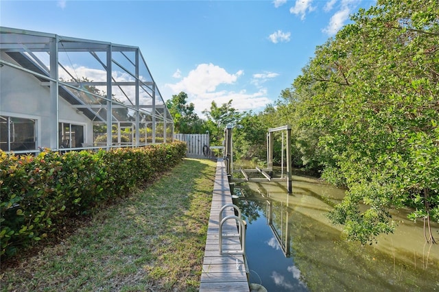 view of yard with a lanai and a water view