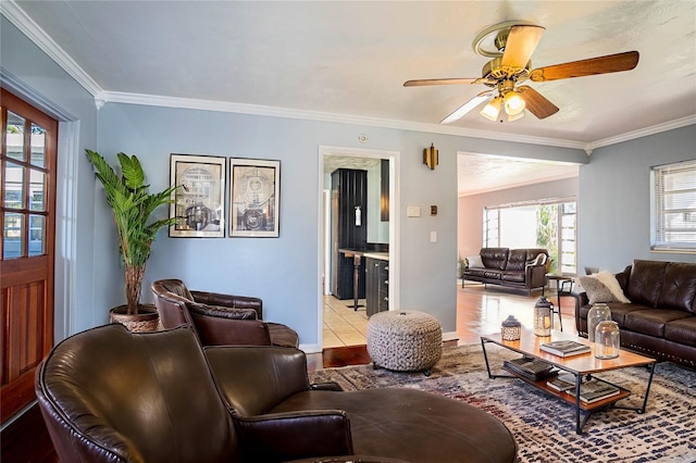 living room with light wood-type flooring, ceiling fan, and crown molding