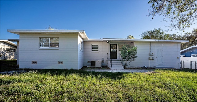 rear view of property with a yard and cooling unit