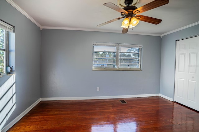 unfurnished bedroom with ceiling fan, dark hardwood / wood-style flooring, crown molding, and a closet