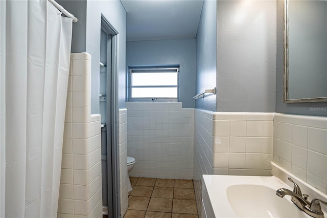 bathroom featuring vanity, tile patterned floors, a shower with curtain, toilet, and tile walls