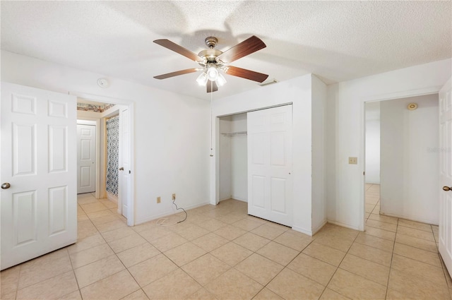 unfurnished bedroom featuring ceiling fan, light tile patterned floors, and a textured ceiling