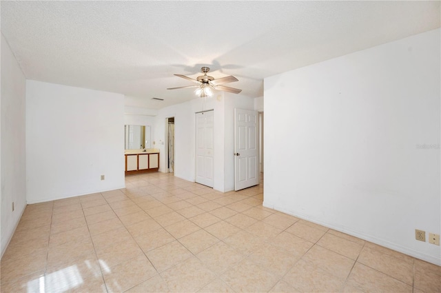 tiled empty room with a textured ceiling and ceiling fan