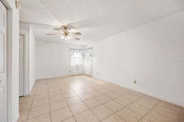 tiled spare room with ceiling fan and a textured ceiling