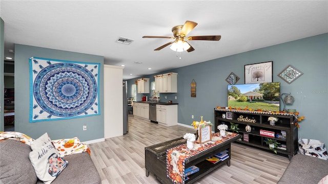 living room with light hardwood / wood-style flooring and ceiling fan