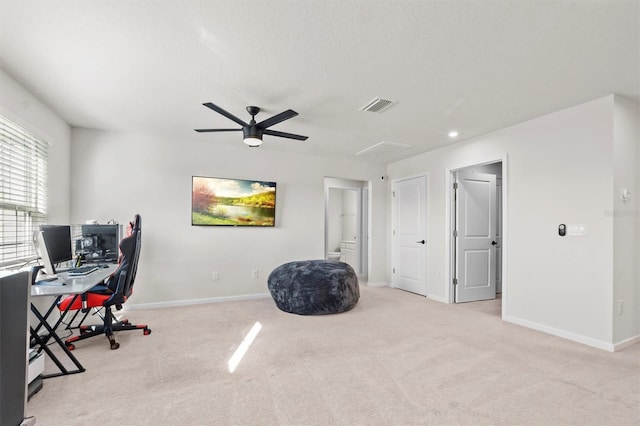 carpeted office space featuring ceiling fan and a textured ceiling