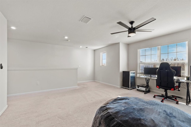 carpeted home office featuring ceiling fan