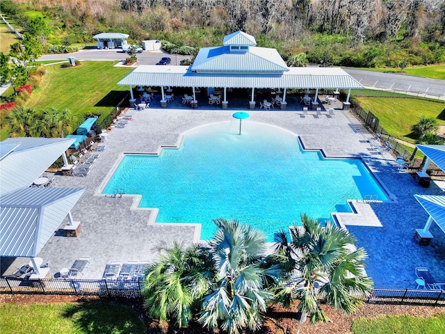 view of pool with a patio and a lawn