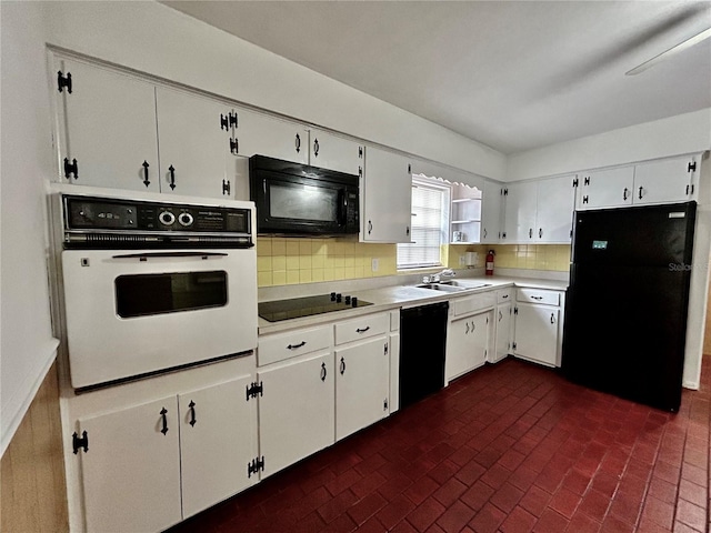 kitchen with black appliances, decorative backsplash, and white cabinets