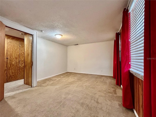 carpeted spare room featuring a textured ceiling