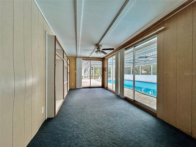 unfurnished sunroom with ceiling fan