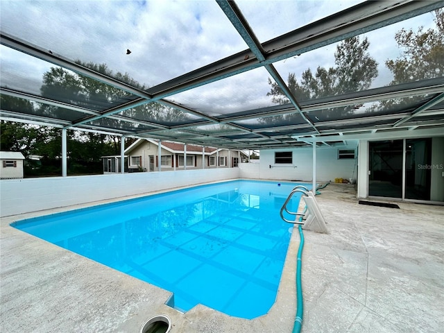 view of pool featuring glass enclosure and a patio area